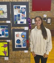 Junior Willa Flynn stands with her entry into the art show that earned her a “Judge’s Choice” purple ribbon.