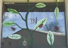 Fernanda Nucamendi painted this resident’s window for spring by painting leaves covered with ladybugs.