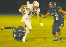 Jacob Ortner runs the ball down the field, trying to avoid being tackled by Sandhills-Thedford’s Mason Cooksley (32) and Brandon Goshorn (12). Photo Courtesy of Aiden Rowley