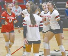 The team celebrates after winning the third set against the Burwell Longhorns, which had to go to extra points. The team won the set 26-24.
