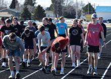 Bulldog track athletes warm up in preparation for practice after returning from spring break.