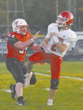 Witten Painter narrowly misses a sack as he blows by defenders to get to St. Mary’s quarterback Gage Hedstrom.