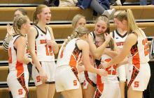 Stanton freshman Haley Happold is embraced by teammates after a buzzer beater Friday night against Pender. Her first varsity basketball game, Happold, who has Down Syndrome, went in for the final seconds of the game and scored the first basket of her career. Photo By Monica Pohlman