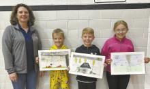 Jessical Pozehl of the Brown/Rock County Emergency Management Agency stands with local contest winners Dax Painter, Brayden Arens and Dallyn Dailey.