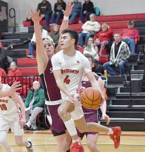 Chris Fernandez looks to pass the ball to a teammate as he gets caught in the Bronco’s defense beneath the basket.
