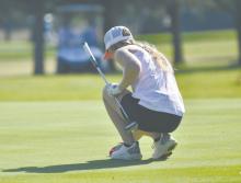 Junior Kenley Welke lines up her ball in preparation to putt. Welke carded a 59 during the Ainsworth Quadrangular, tying for 17th place.