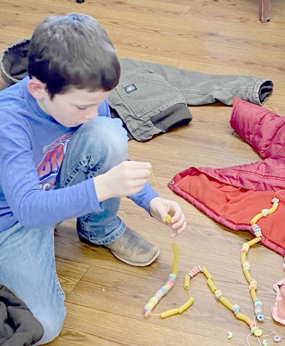 Blake Winters kept busy making his string longer for the tree garland.