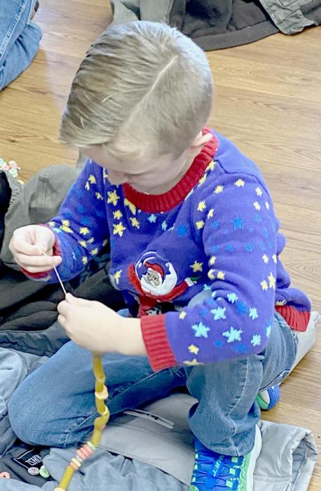 Brylee Barta and Bentley Mashburn work on making their strands to be added to the garland.