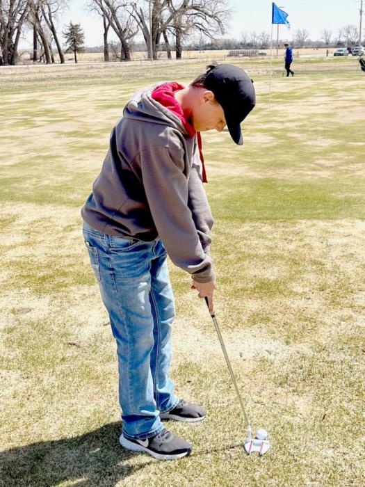 AMS Golfer Kaden Evans prepares for a chip shot near the hole at the Bassett Country Club.
