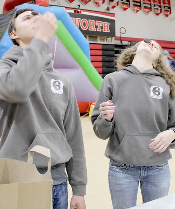Brett Alder (left) and Jaycily Johnson (right) try their hand at balancing cookies during Post Prom games.