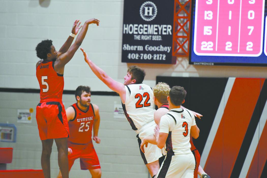 Ainsworth senior Witten Painter (22) attempts to block a shot taken by Winside’s Jahiem Hamik (5).