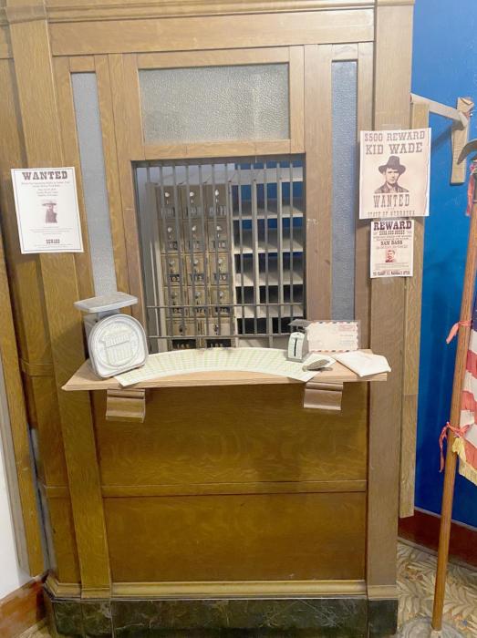 This photo was taken in the Long Pine Heritage House Museum in the “Outlaw Room.” It depicts a post office with wanted posters for Doc Middleton and Kid Wade.