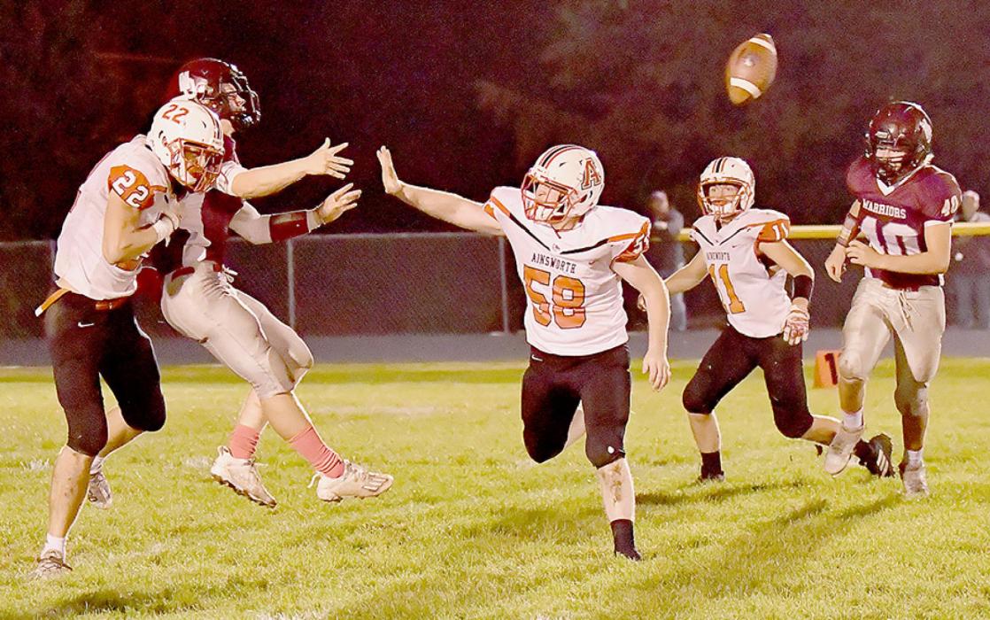Carter Nelson gets to Neligh-Oakdale’s quarterback in the second quarter. Jensen Williams, #58, was also zeroing in on the Warrior quarterback.