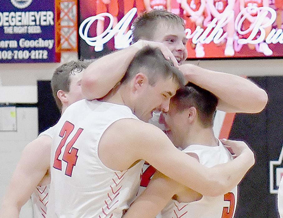 Ainsworth’s three starting seniors celebrated after their 76-53 win over Axtell and gaining a berth in the Boys Basketball Championship.