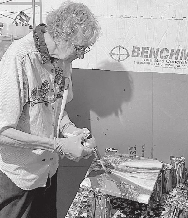 Carol Larson demonstrates torching her acrylic paints to bring out special effects.