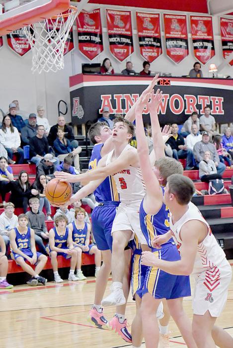 Traegan McNally drives through three West Holt defenders on his way to the basket. McNally scored 20 points for Ainsworth against the West Holt Huskies.