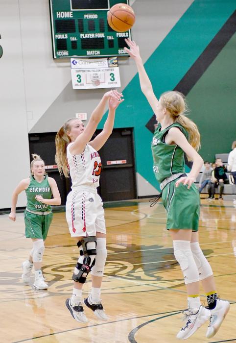 Ainsworth’s Kendyl Delimont shoots over Elkhorn Valley’s 6’ 2” freshman JJ Black for two points.