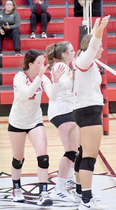 Below: Bulldog seniors Summer Richardson, Libby Wilkins and Kaitlyn Nelson wait at the net for the ball during the Bulldogs’ game against the Broncos.