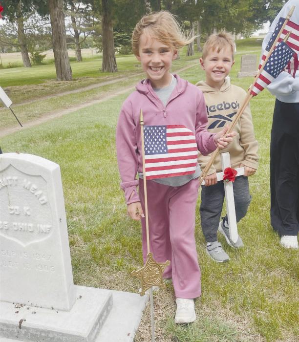 Parker and Jameson Fairhead place flags and crosses at graves around the cemetery.