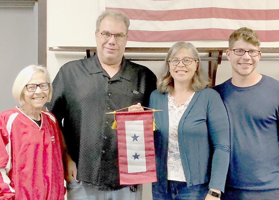 Mary Halvorson (left) presented the Blue Star Service Banner to Kevin and Sarah Price on behalf of their son, Wyatt who will be deployed soon to Estonia.