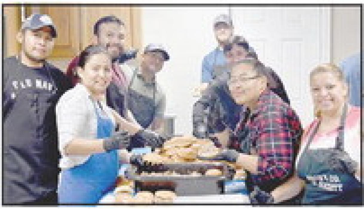 Employees from GJW prepared the sandwiches for the Free Pork Feed.