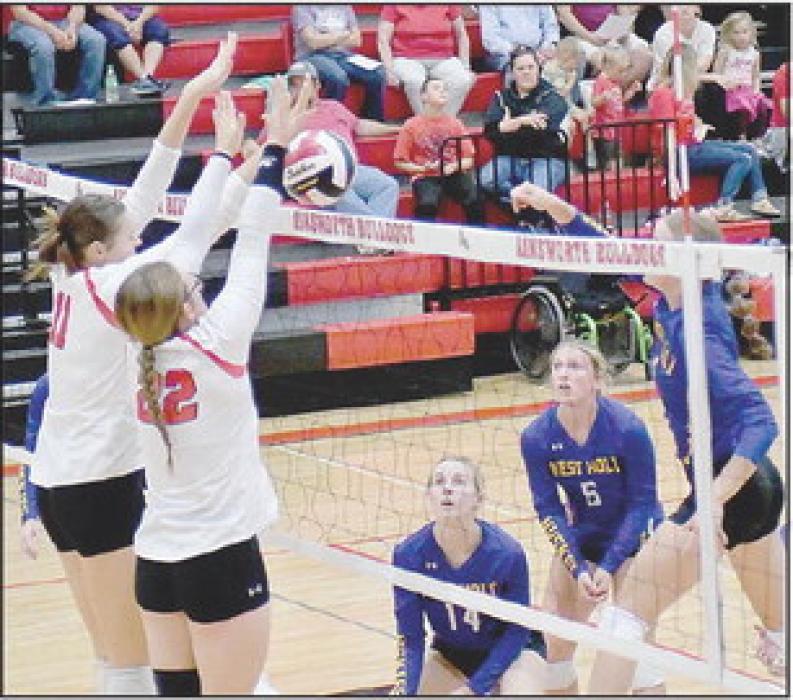 Up against a tough West Holt team, Karli Kral (11) and Gracyn Painter (22) go up for the block.