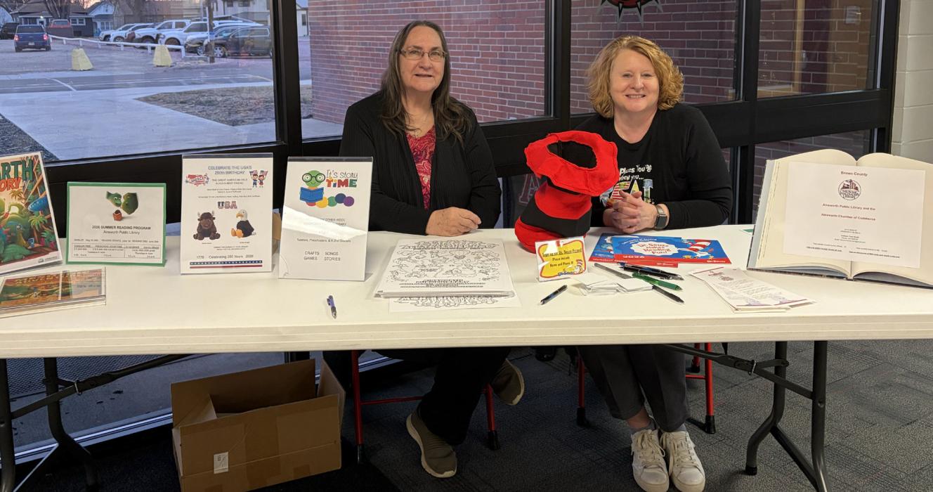 Gail Irwin (left) and Laurie Goodloe (right) sit at the welcome table at the ESU event held on Monday, March 2. The table promoted reading programs to be held at the Ainsworth Public Library during the summer months. The Family Literacy event showed families ways to make reading and learning at home meaningful and fun for the whole family. Dinner, door prizes, and books were provided to all who attended. ESU 17 serves children from Brown and Rock counties, ages birth - fifth grade.
