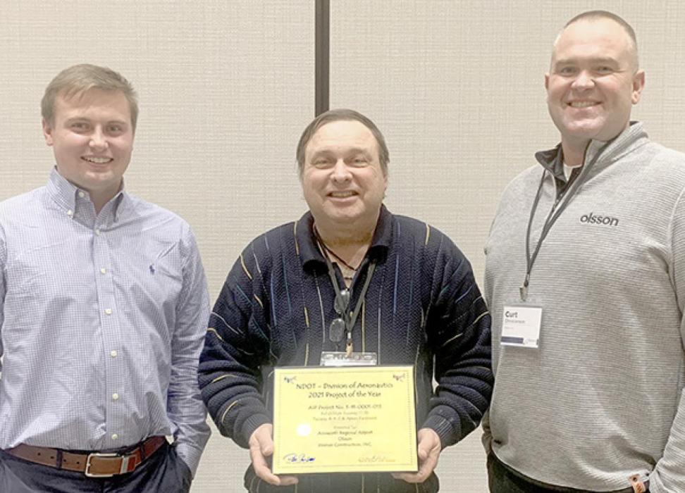 Lance Schipporeit (center), Manager of the Ainsworth Regional Airport, Drake Harrington (left) and Curt Christianson (right), both of Olsson, accept an award for the 2021 Airport Improvement Project of the Year at the Nebraska 30th Annual Aviation Symposium on January 27th in Kearney. Not pictured are representatives from Werner Construction. The project winning the award was Ainsworth’s $7 million rehabilitation of Runway 17-35, Taxiways A, B, C &amp; Apron Pavement, which was completed in November 2021.