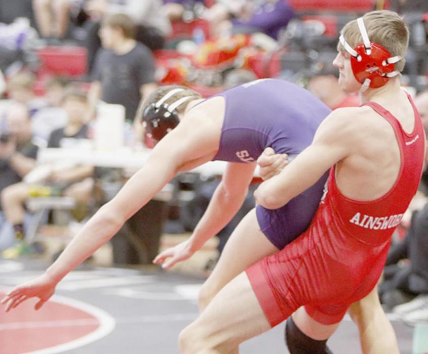 Owen Blumenstock grabs his opponent David Smolik of Minden in their match in the 145 lb. weight class.