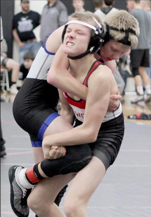 Mason Painter strains for a lift and take down at the Class D-1 District wrestling competition.