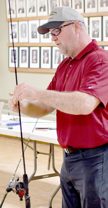 Klage is pictured to the right showing the proper way of stringing line through a fishing pole.