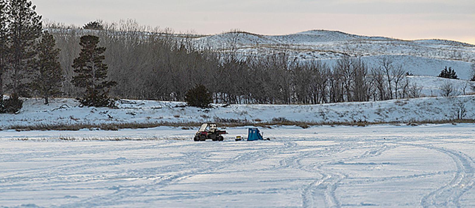 Deep tracks lead to an ice-fishing spot at snow-covered Smith Lake Wildlife Management Area in early January. The popular lake is among many in the Sandhills that are suffering from low oxygen levels. (NGPC/Justin Haag)