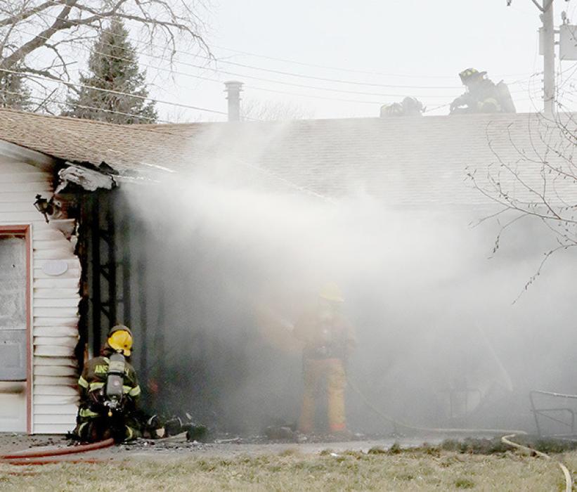 Firemen concentrated water on the north side of the garage while other firemen got on the roof to open holes to fight the fire in the attic area.