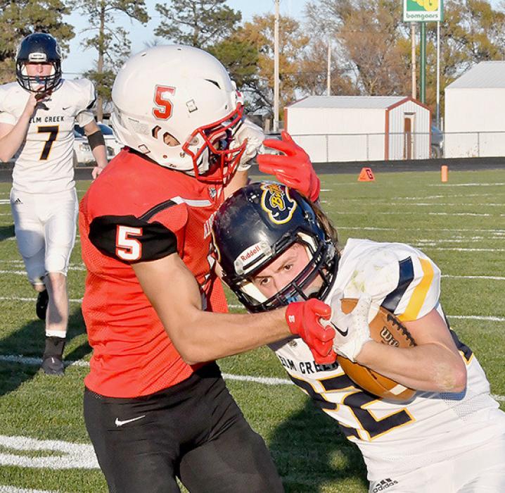 Elm Creek’s Jaxon Smith gets away with a facemask penalty in the second quarter as he hangs onto Owen Blumenstock’s facemask.