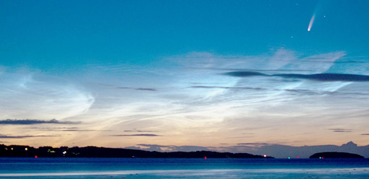 Comet NEOWISE flies high above a batch of noctilucent clouds in this photo from Wikimedia contributor Brwynog. License and source CC BY-SA 4.0 https://commons.wikimedia.org/wiki/File:Comet_Neowise_and_noctilucent_ clouds.jpg