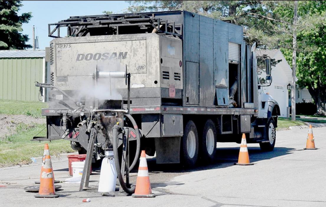 Above, the city installs new cured-in-place sewer pipe lining through a manhole in Ainsworth’s streets during June 2020. A new flexible liner is inserted down a manhole into the existing sewer main line, inflated, and heated until it hardens, creating a new liner and restoring the pipe’s condition.