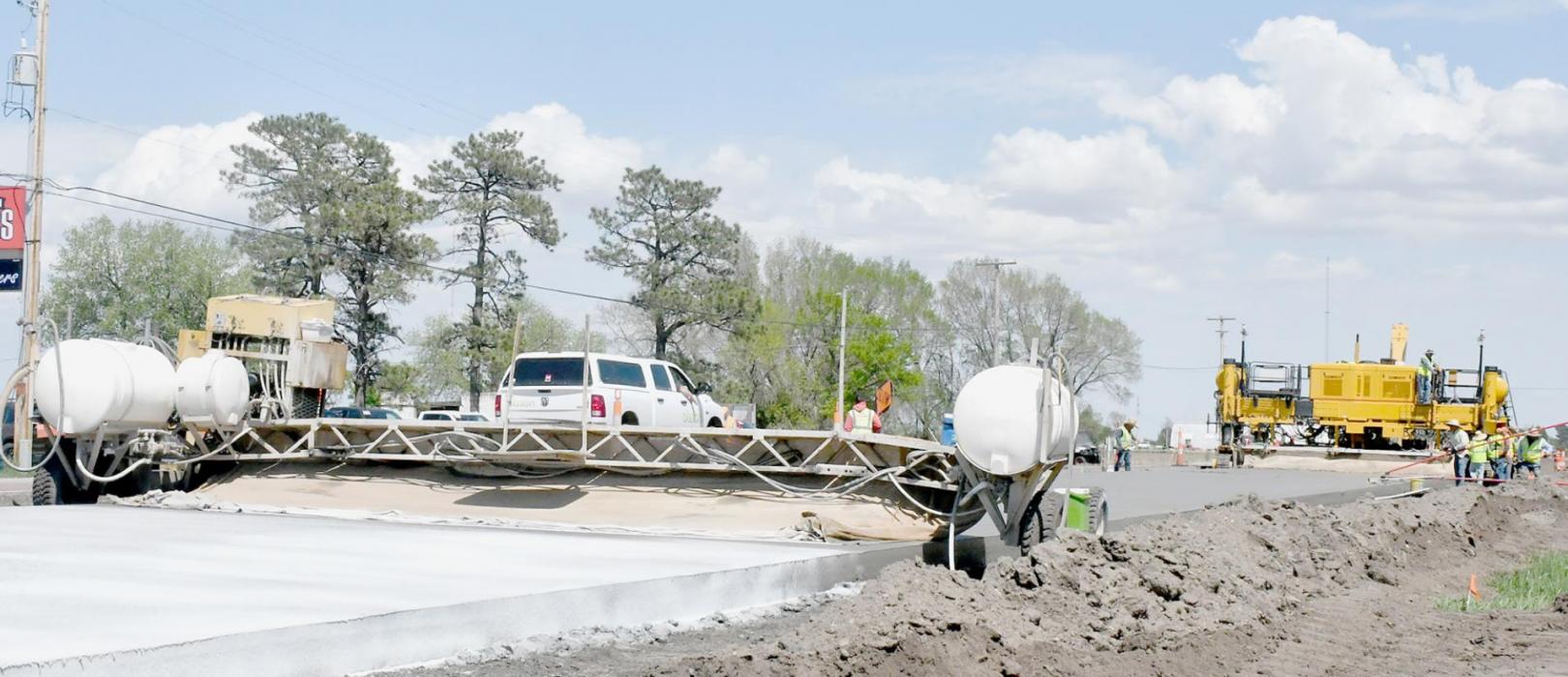 Highway 20 construction work on the east edge of Ainsworth has progressed to laying concrete from Richardson Drive to the edge of city limits. The photo above shows the concrete work between Bomgaars and Ainsworth Motors on Tuesday, May 17th. New concrete is being laid by the large machine on the right and is drying on the left.