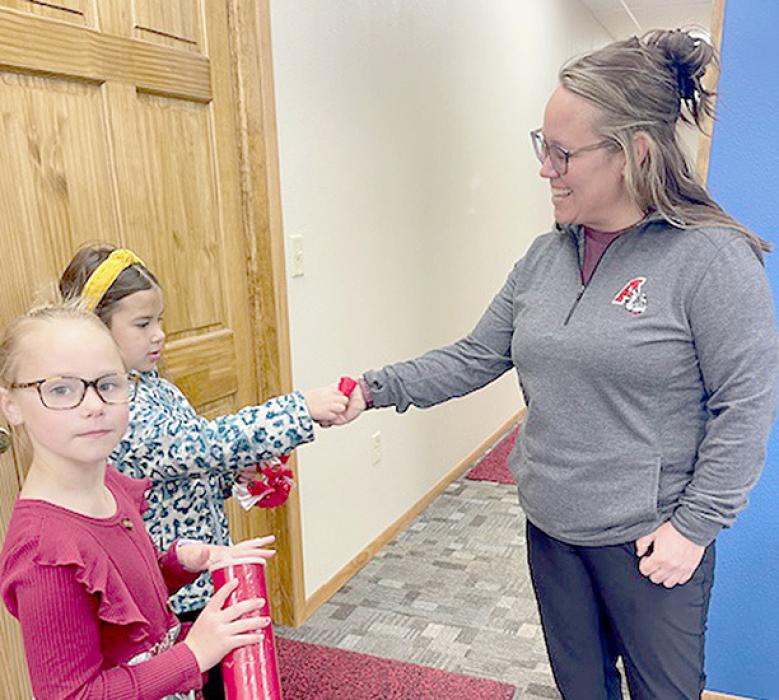 Tiffany Barthel (right) of Palmer Law was one of the many businesses that received poppies for their donations. Selling the poppies were Gracyn Peterson (left) and Brynn Pierce (center).