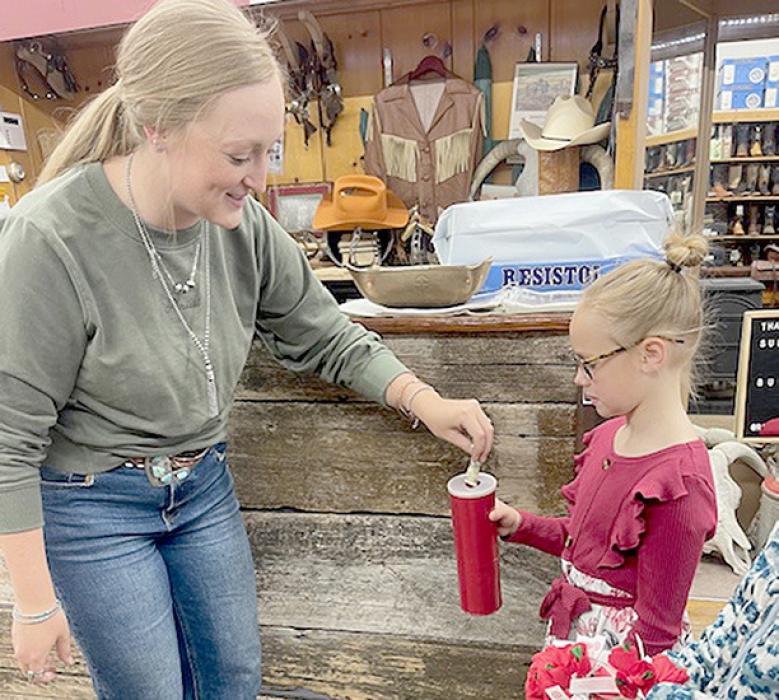 Rhe’Ann McBride (left) at Ranch-Land Western Store made a donation to Gracyn Peterson of the Jr. Auxiliary that received poppies in return.