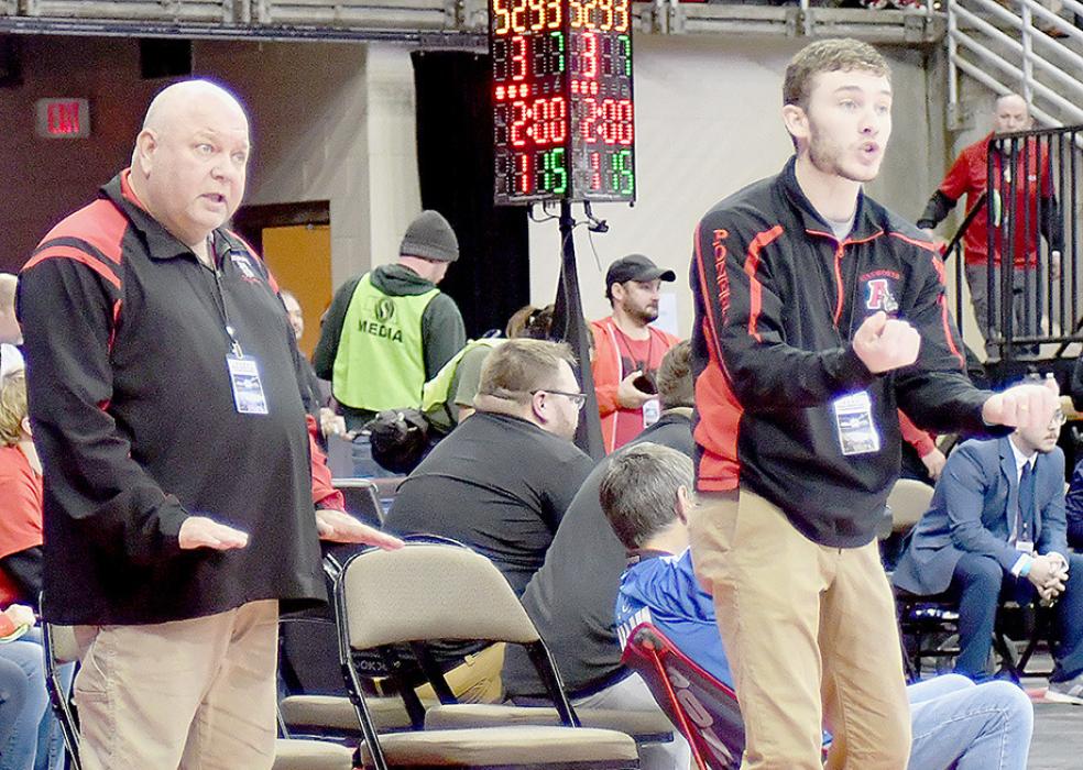 Head Coach Todd Pollock indicates for Pozehl to take it easy and stay calm in her bid for third place in the 115 lb. weight class.