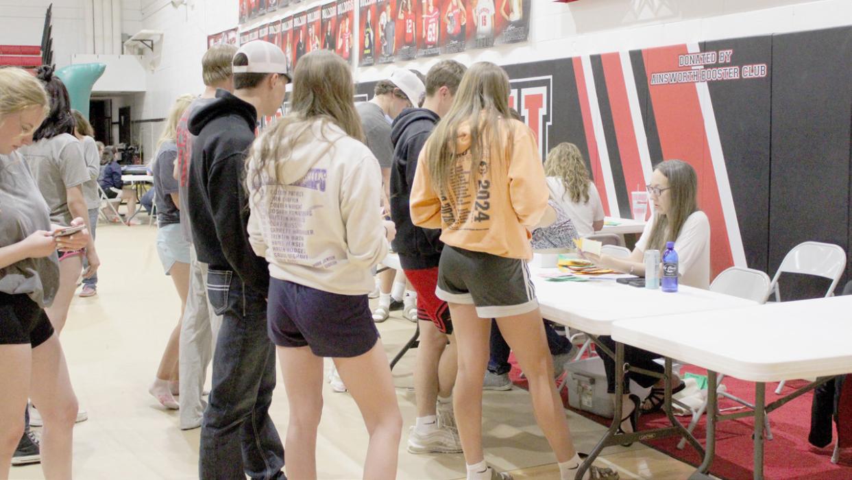 Students wait in line to collect their earnings from the bank so they know how much play money they have to spend on the prizes up for grabs.