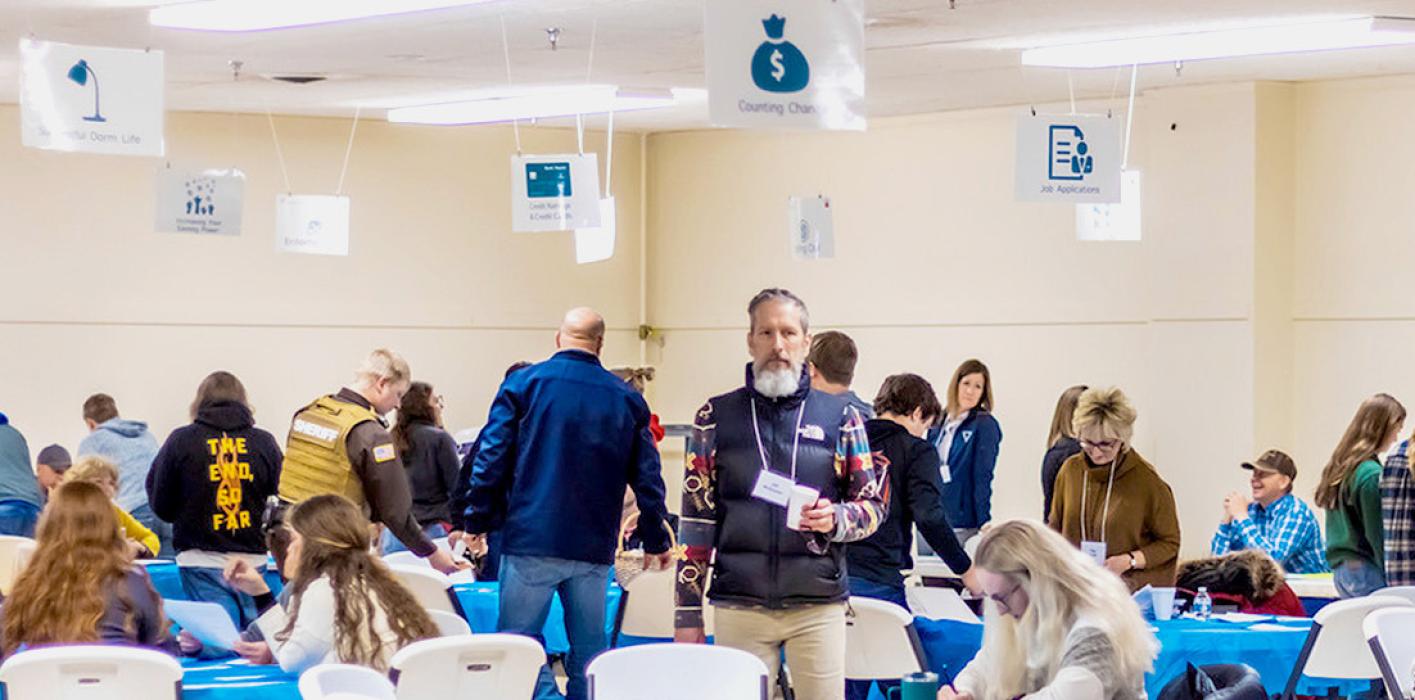 Looking up, you can see the many different stations for the youth to learn basic life skills from including pet ownership and job applications, dorm life, credit rating and credit cards to name a few. Mr. McQuistan, center, welcomed the students to the program. Photos by Laura Vroman