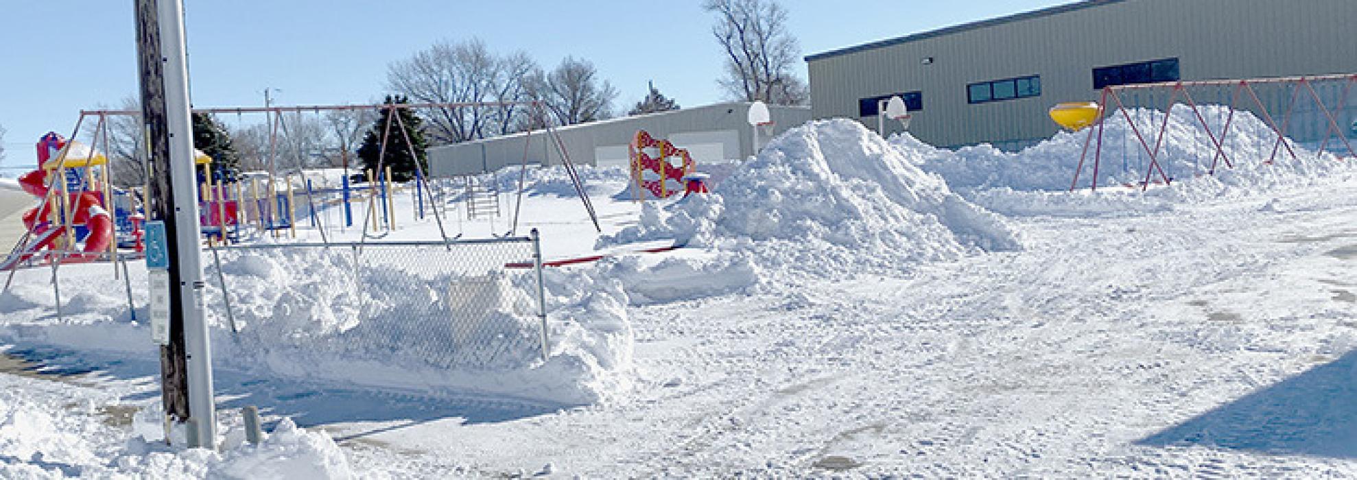 Areas like Ainsworth Community Schools are piled high with snow and have to decide whether to wait for the snow to melt or haul the snow out before another storm comes through the area.