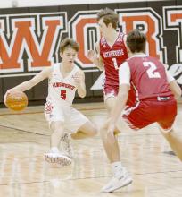 #5 sophomore Traegan McNally jukes out Swede defenders as he brings the ball up the court. McNally leads AHS in points per game with an average of 13.3. Photos by Debb Gracey