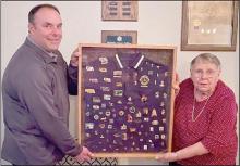 Lion President Dale Hafer (left) and Mary Ann Allen (right) hold Lion Jerry Allen’s collection of pins from his years of service. The collection will be included in the Lions Club award display. (Top Picture)