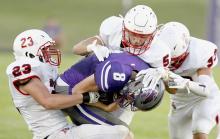Cole Swanson - #23, Owen Blumenstock - #5 and Aiden Jackman - #33 combine to stop Hartington-Newcastle’s quarterback Cole Heimes.