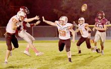 Carter Nelson gets to Neligh-Oakdale’s quarterback in the second quarter. Jensen Williams, #58, was also zeroing in on the Warrior quarterback.