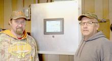 Brad Miller, City of Ainsworth Water/Sewer Superintendent (right) and Bryan Sisson, City of Ainsworth Assistant Water/Sewer Superintendent (left) stand in front of the well and lift station monitoring system that the cyber security update grant helps to protect from a cyber attack.