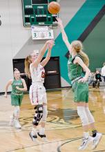 Ainsworth’s Kendyl Delimont shoots over Elkhorn Valley’s 6’ 2” freshman JJ Black for two points.
