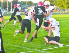 Three Bulldogs, Zaine Evans (2), Graham Duester (13), and Ben Clingman (7), work to take down O'Neill St. Mary's Ben Barlow (3).